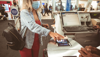 Woman scanning mobile boarding pass at gate